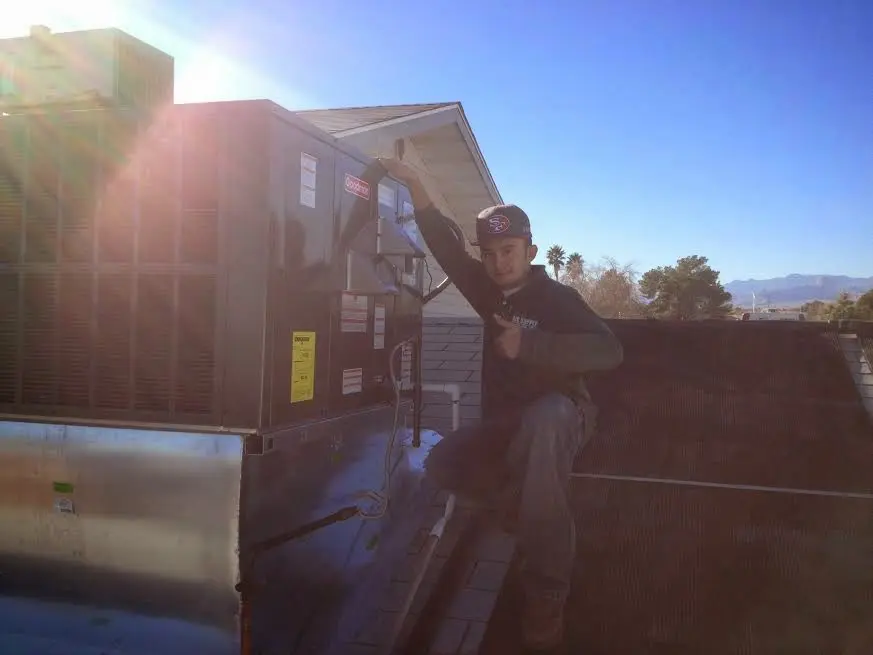 HVAC technician performing Air Duct Repair on a rooftop unit in South Brooksville